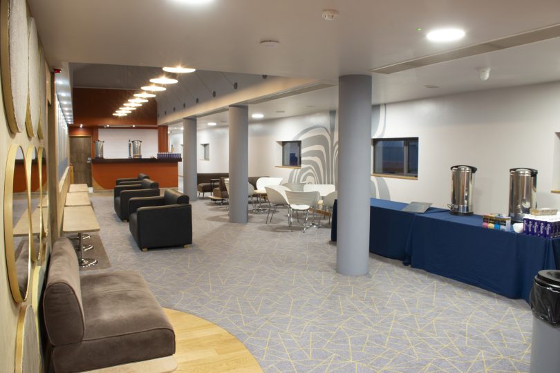 Modern lounge area at the Millennium Forum featuring stylish seating, warm lighting, and a refreshment station, ideal for business events and networking.