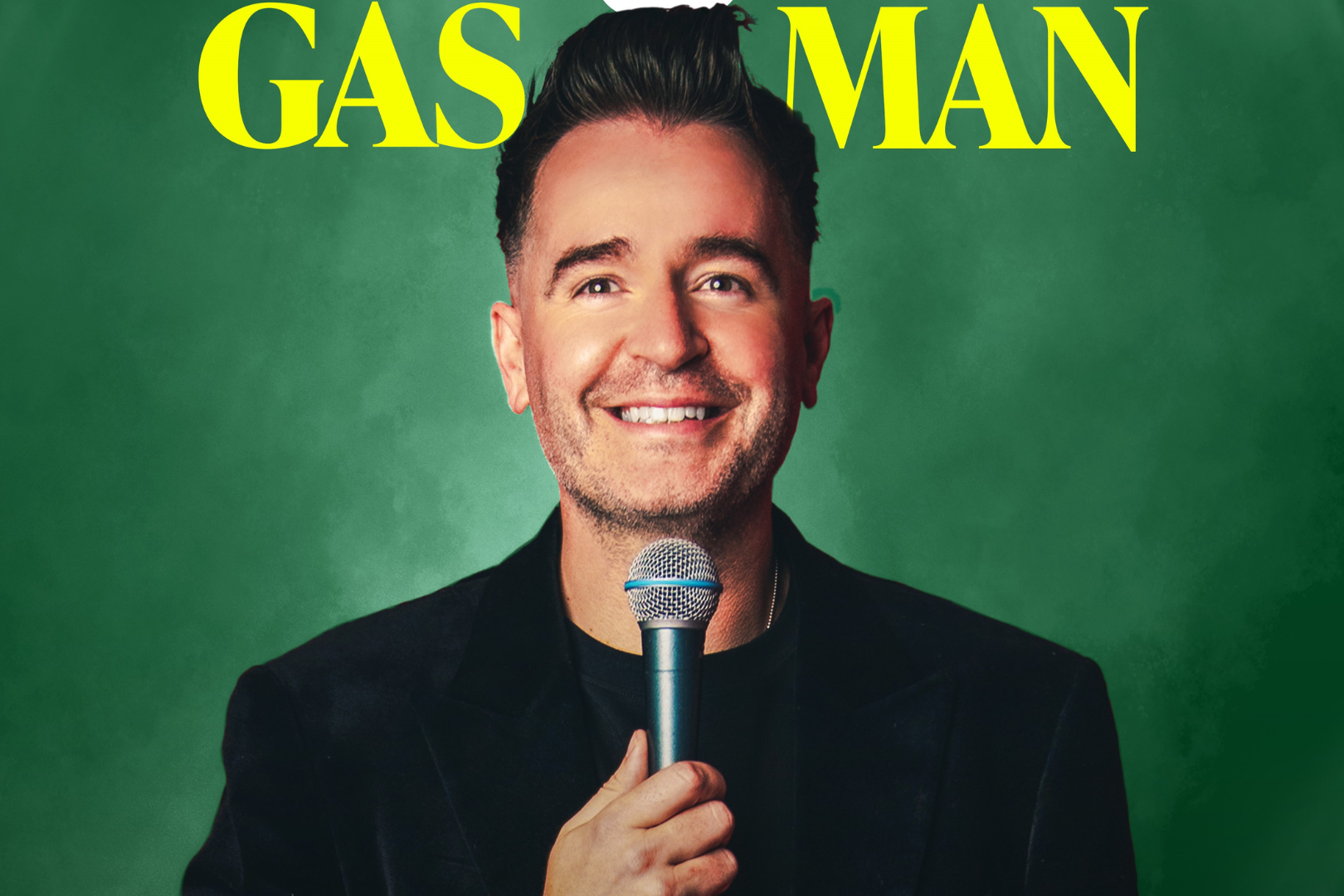 Promotional image for a comedy show titled Gas Man. A smiling male comedian is shown holding a microphone against a deep green background. He wears a black jacket and looks directly at the camera, exuding warmth and confidence. The title GAS MAN appears in large, bold yellow text above his head. The clean and bold design suggests a sharp, engaging stand-up performance.